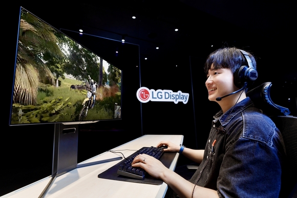 ▲LG디스플레이 모델이 4세대 기술이 적용된 27인치 OLED 모니터 패널로 게임을 즐기고 있다. / 사진=LG디스플레이 LG디스플레이, 궁극의 게이밍 OLED 패널 양산