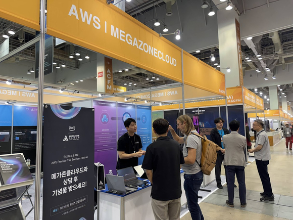 ▲부산 벡스코 제2전시장 ACFM 2025 현장에서 메가존클라우드 직원이 부스를 찾은 외국인 관람객들에게 클라우드 기반 미디어 제작 솔루션을 설명하고 있다. / 사진=메가존클라우드 메가존클라우드, 아시아콘텐츠&필름마켓서 미디어 제작 혁신 선보여